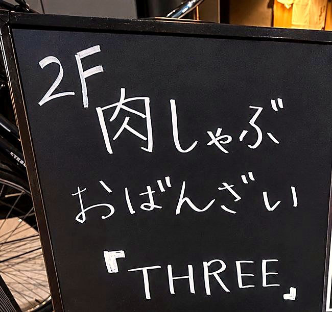ビル前の看板「2F 肉しゃぶ おばんざい THREE」